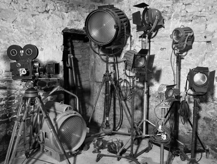 Historische Filmkamera und mehrere Scheinwerfer in einem steinernen Raum