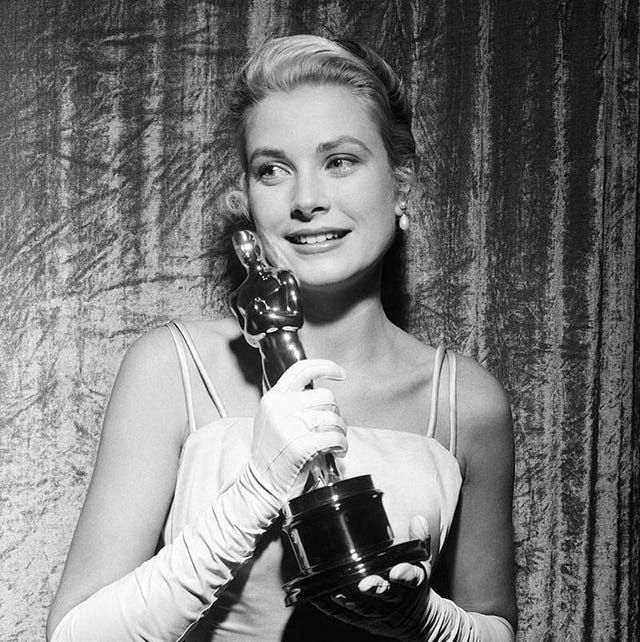 Schwarz-Weiß-Porträt einer Schauspielerin mit Oscar-Trophäe und langen Handschuhen