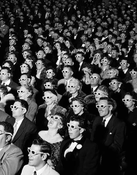 Schwarz-weißes Kinopublikum mit zahlreichen 3D-Brillen im Saal