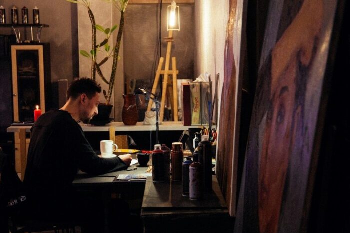 Künstler arbeitet in einem Atelier an einer großformatigen Filmillustration